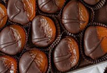 Assorted chocolate truffles in paper liners arranged in a box.