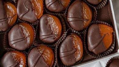 Assorted chocolate truffles in paper liners arranged in a box.