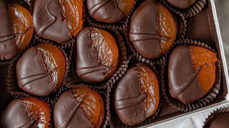 Assorted chocolate truffles in paper liners arranged in a box.