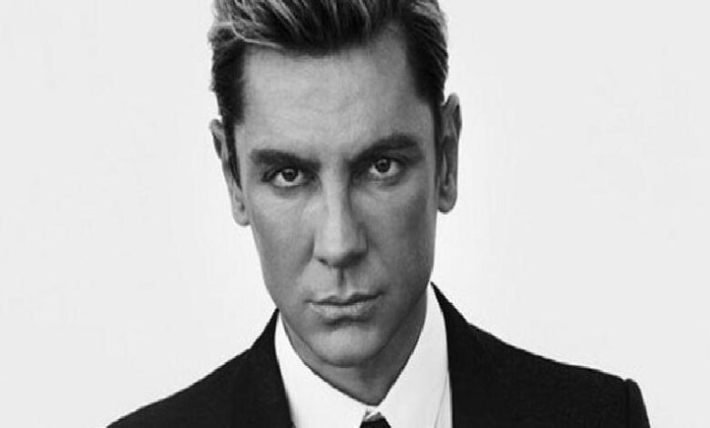 Black-and-white headshot of a man in a suit looking directly at the camera.