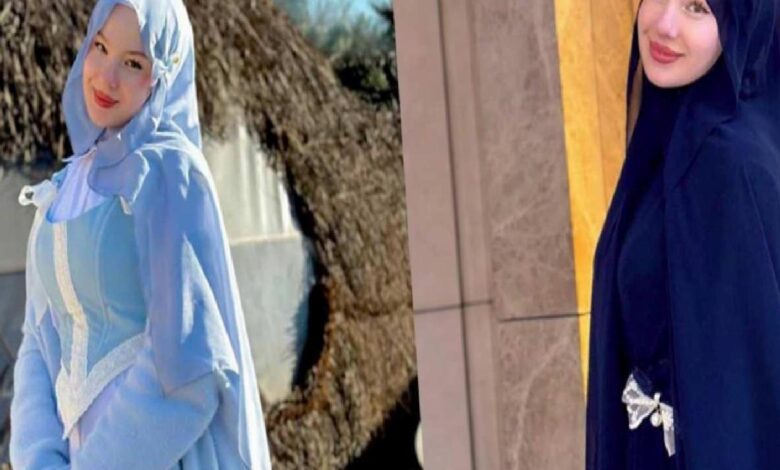 Two women wearing hijabs and long dresses posing side by side outdoors, one in light blue and the other in dark navy.