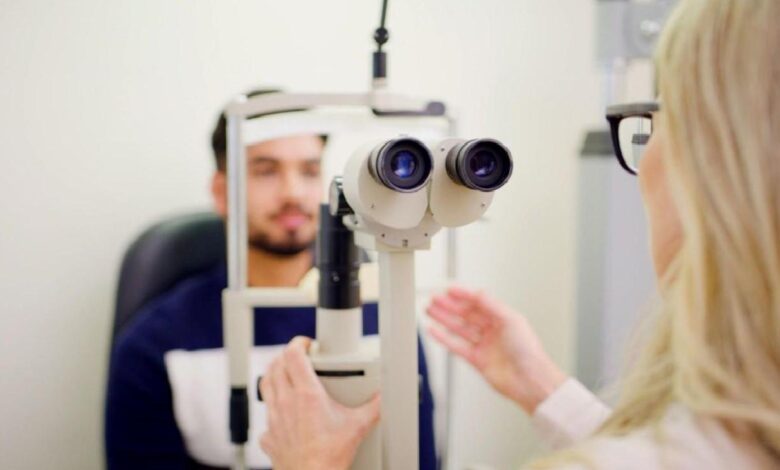 Optometrist uses a slit lamp to examine a patient’s eyes during an eye exam.