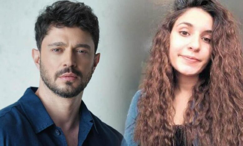 Man with dark hair and stubble in a blue shirt beside a woman with long curly brown hair, both looking at the camera.