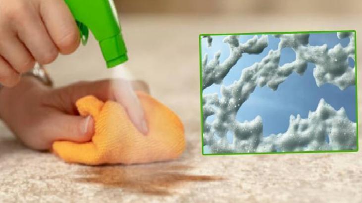 A hand uses a green spray bottle to wipe a spill with an orange cloth on a beige floor; inset shows frost crystals on a window.