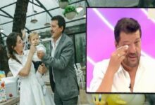 Mother and father with their baby at a celebration, under a bright indoor setting; an inset TV screen shows a man wiping his eye.