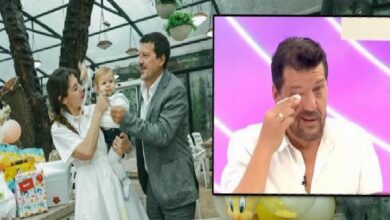 Mother and father with their baby at a celebration, under a bright indoor setting; an inset TV screen shows a man wiping his eye.