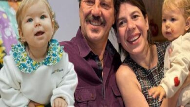 Smiling couple holds two young children for a group photo: girl on the left and a baby on the right.