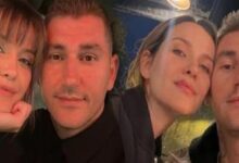 Four friends taking a selfie, leaning in and smiling at the camera.