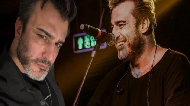 Two male musicians on stage during a live performance, one looking at the camera while the other sings into a microphone.