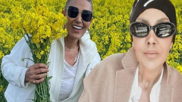 Two women wearing sunglasses pose in a bright yellow canola field; one holds a bouquet of yellow blooms.