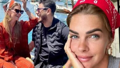 Woman in a red bandana faces the camera, resting her cheek on her hand, with two friends chatting and smiling on a sunny boat in the background.