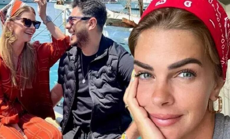 Woman in a red bandana faces the camera, resting her cheek on her hand, with two friends chatting and smiling on a sunny boat in the background.