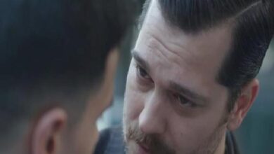 Close-up of a man with a mustache looking intently at another person during a tense moment.