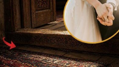 Close-up of a carved wooden doorway threshold and patterned rug; a red arrow points to the rug edge, with a circular inset showing a couple holding hands.