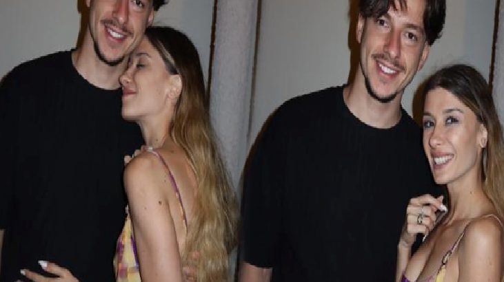 Two couples pose together at a party, smiling for the camera in casual outfits.
