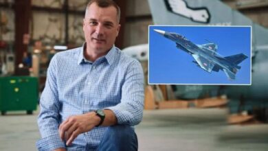 Man in a blue checkered shirt kneeling in a workshop, with an inset photo of a fighter jet in blue sky.