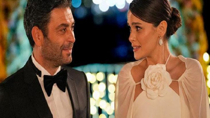 Man in a black tuxedo and a woman in a white gown sharing a conversation at a formal evening event.