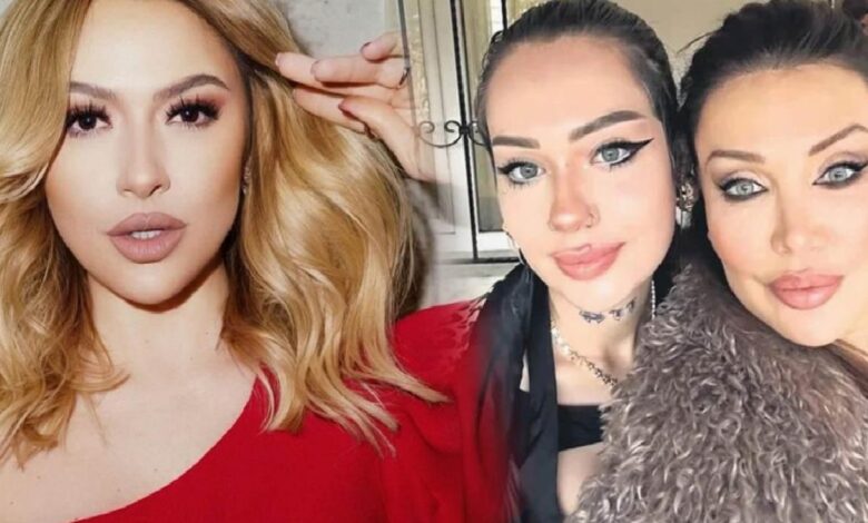 Three women posing for a close-up selfie indoors: a blonde in a red top on the left, and two women with dark hair and bold makeup on the right.