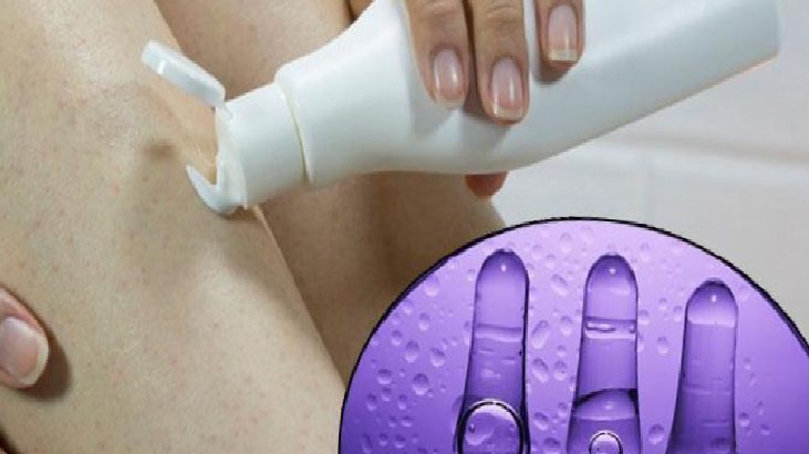 Person applying lotion or cream to the underarm with a pump bottle; close-up of the application area and product.